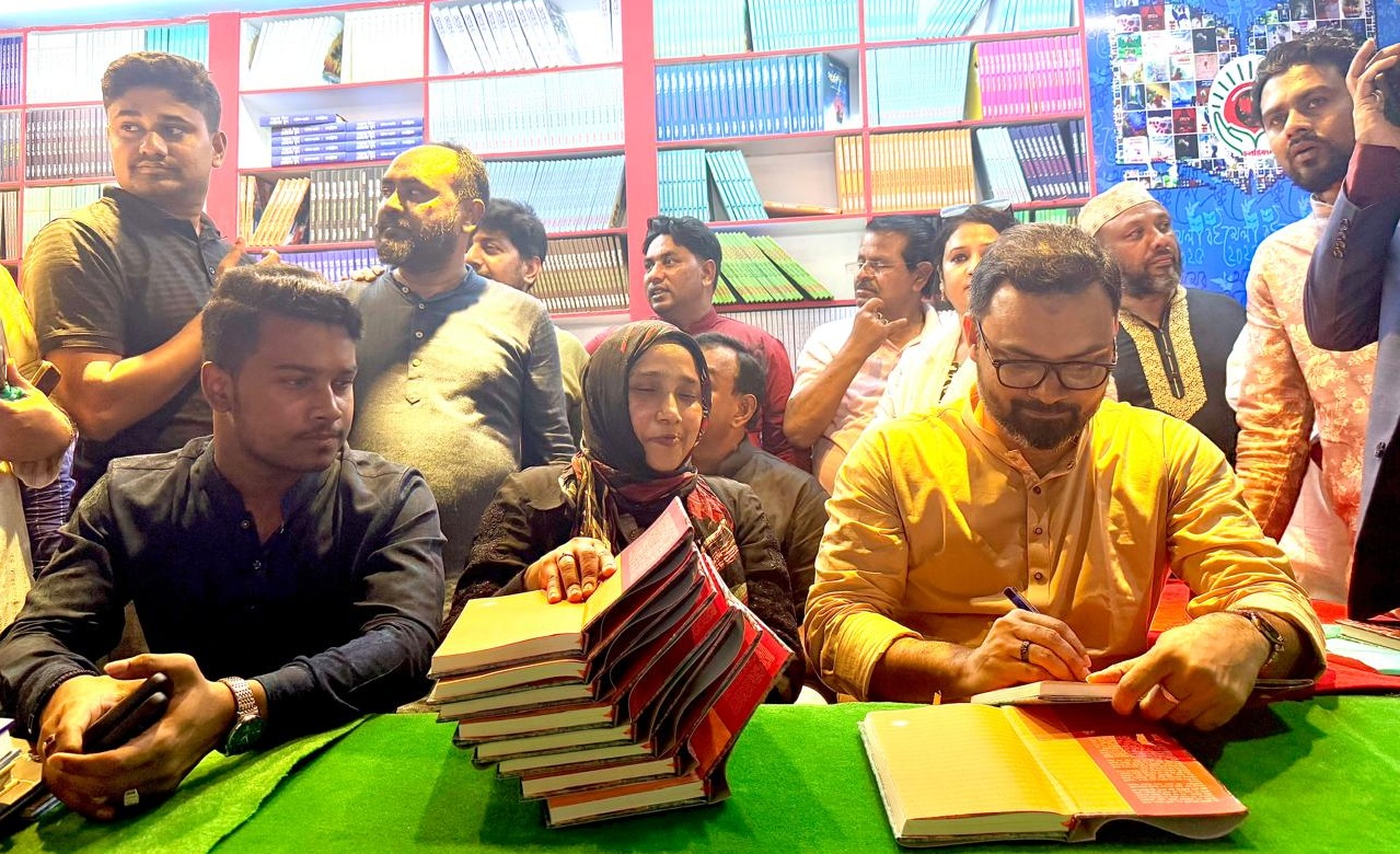 চলন্তিকায় নিজ বইয়ে অটোগ্রাফ দিচ্ছেন আমিনুল হক
