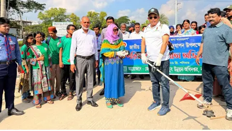 বরিশালে পরিচ্ছন্নতা অভিযানে নিজ হাতে ঘাস কাটলেন বিভাগীয় কমিশনার ও জেলা প্রশাসক
